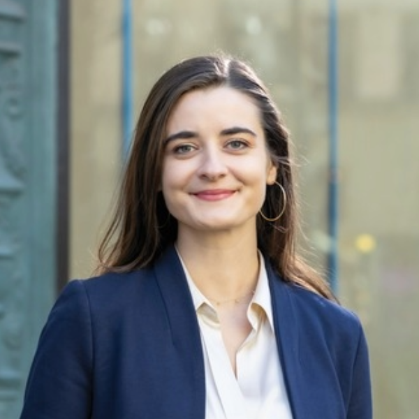 Headshot of woman in white shirt and blue jacket with long hair