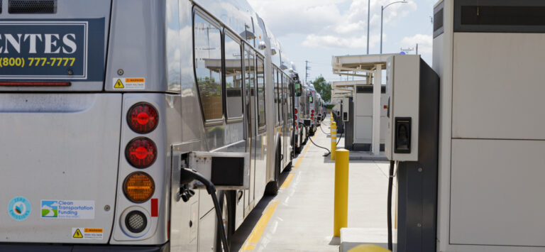 Electric buses lined up at charging stations.