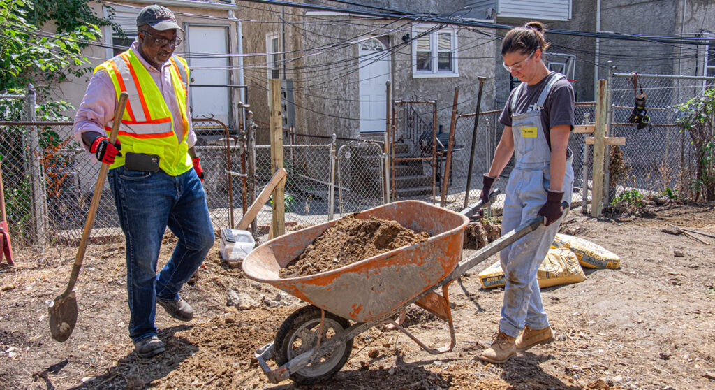 STV staff move dirt at a Habitat for Humanity site.