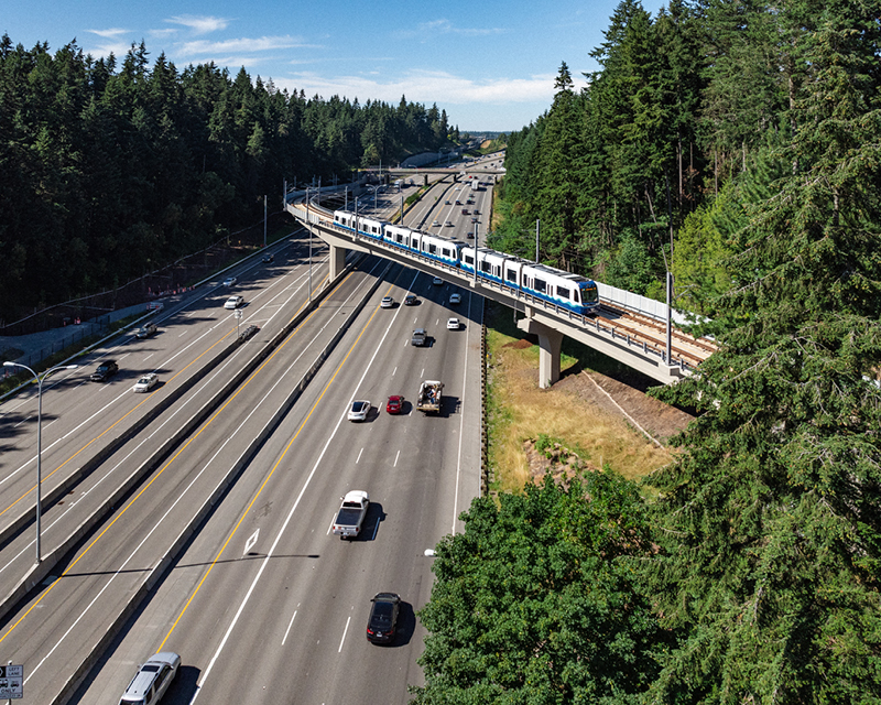 A four-car light rail vehicle crosses over I-5 on the 1 Line Link Extension to Lynnwood