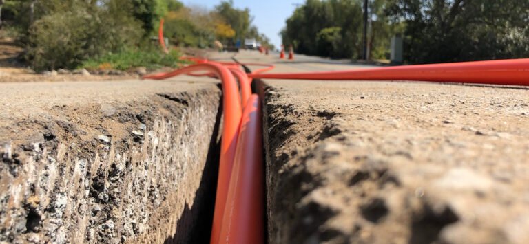 Fiber lines being installed under a road