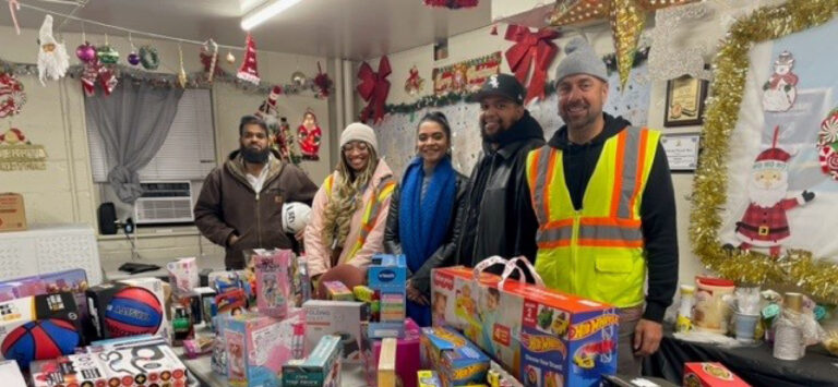 Members of STV's NYCHA Comprehensive Modernization team staff gather this years toy donations.