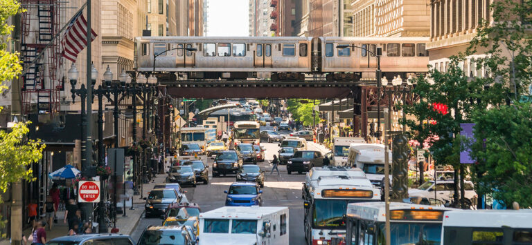 View of Chicago city street showcasing elevated rail service and city bus.