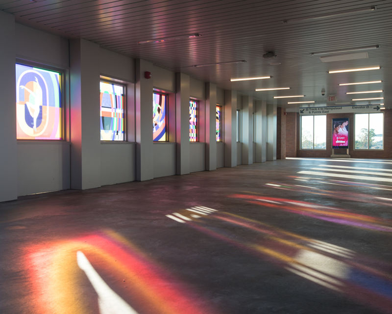 Sun shines through art-filled windows of the overpass.