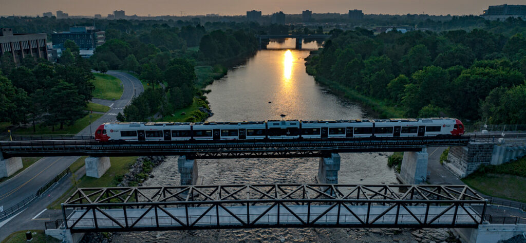 Ottawa O-Train South light rail transit extension passing over a rail bridge.