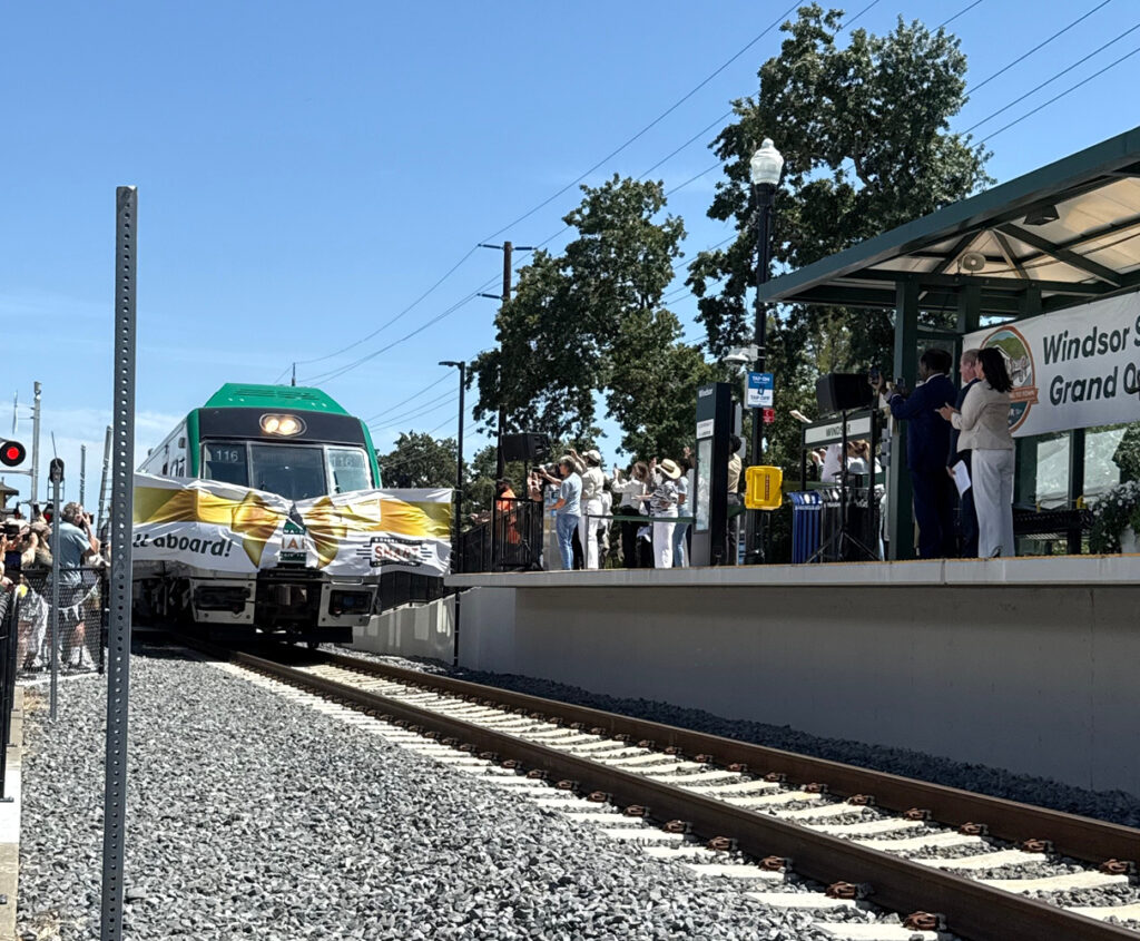 A SMART train breaks through a ceremonial banner while arriving at Windsor Station.