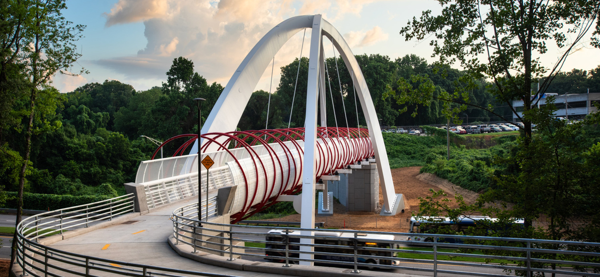 Ground-level view of Global Gateway Connector Bridge showcasing its unique steel arches and pedestrian bridge walkway.