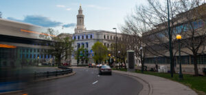 A blurred moving bus cross a street in a busy city center in Denver, Colorado.
