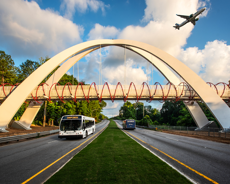 Buses pass under the Global Gateway Connector Bridge.