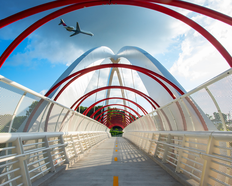 A plane heading to Hartsfield-Jackson Atlanta International Airport passes over the Global Gateway Connector Bridge.