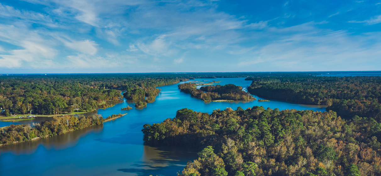 An aerial drone shot of Lake Houston surrounded by trees in Kingwood, Texas