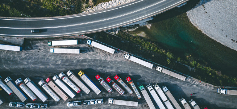 Aerial top view of trucks parked by the road.