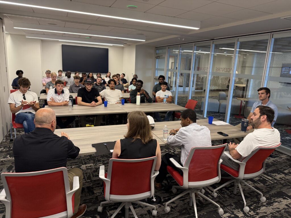 Full assembly of TQI Shared Intern Program participants meeting in a conference room before a site visit