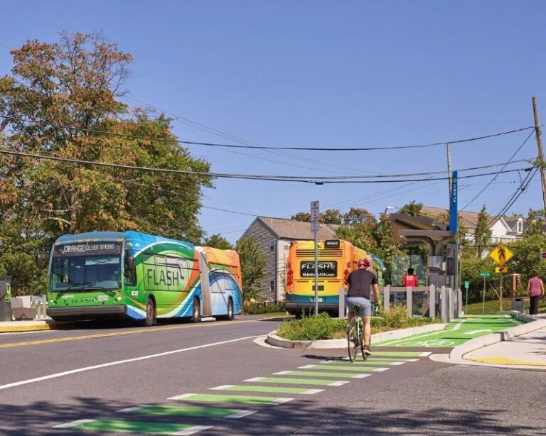 A Flash BRT vehicle in revenue service in Montgomery County, Maryland with pedestrian and cyclists using anciliary roads and paths.