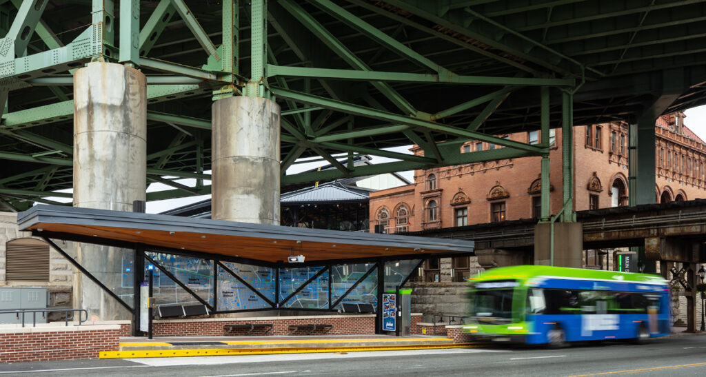 A Richmond Pulse bus pull up to a stop under an elevated roadway.