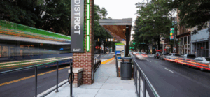 Image of a blurred BRT bus passing a transit station in Virginia.