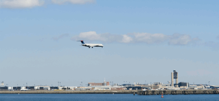 Aerial view of a passenger airplane landing at Logan Airport in Boston, Massachusetts.
