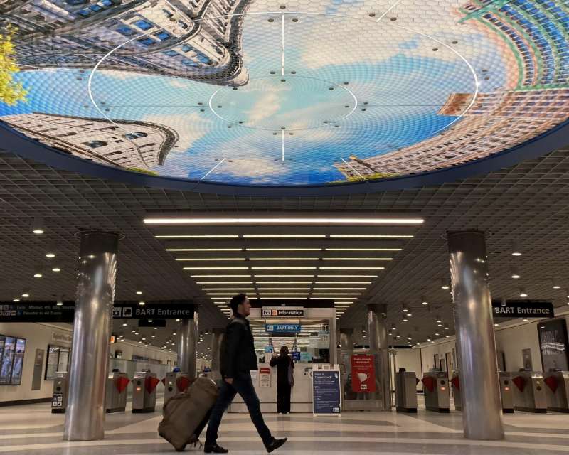 View of commuter passing through main area of Powell Street BART station.