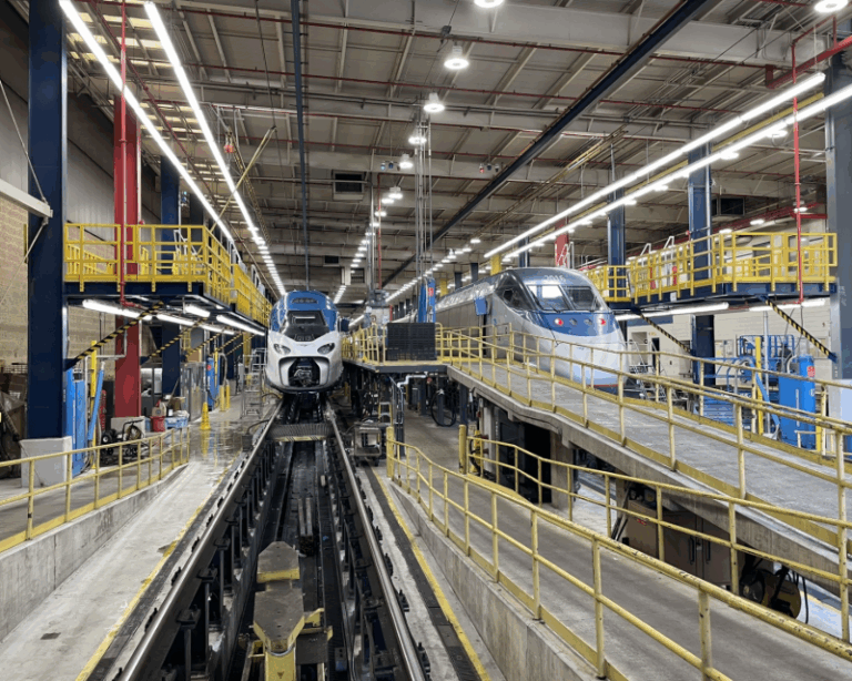 Interior view of Amtrak's Ivy City maintenance facility in Washington, D.C., with two Acela trains in service bays.