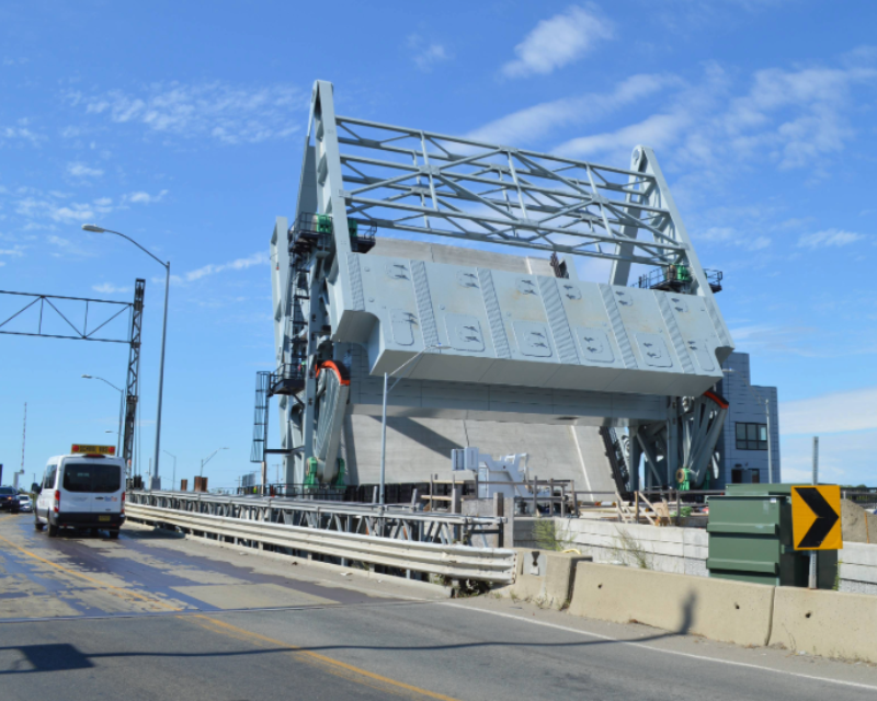 View of Belden G. Bly drawbridge in open position from opposite side of the roadway in Massachusetts.