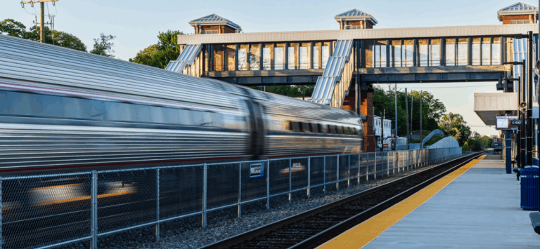 Blurred Amtrak train passing through a station in Virginia.