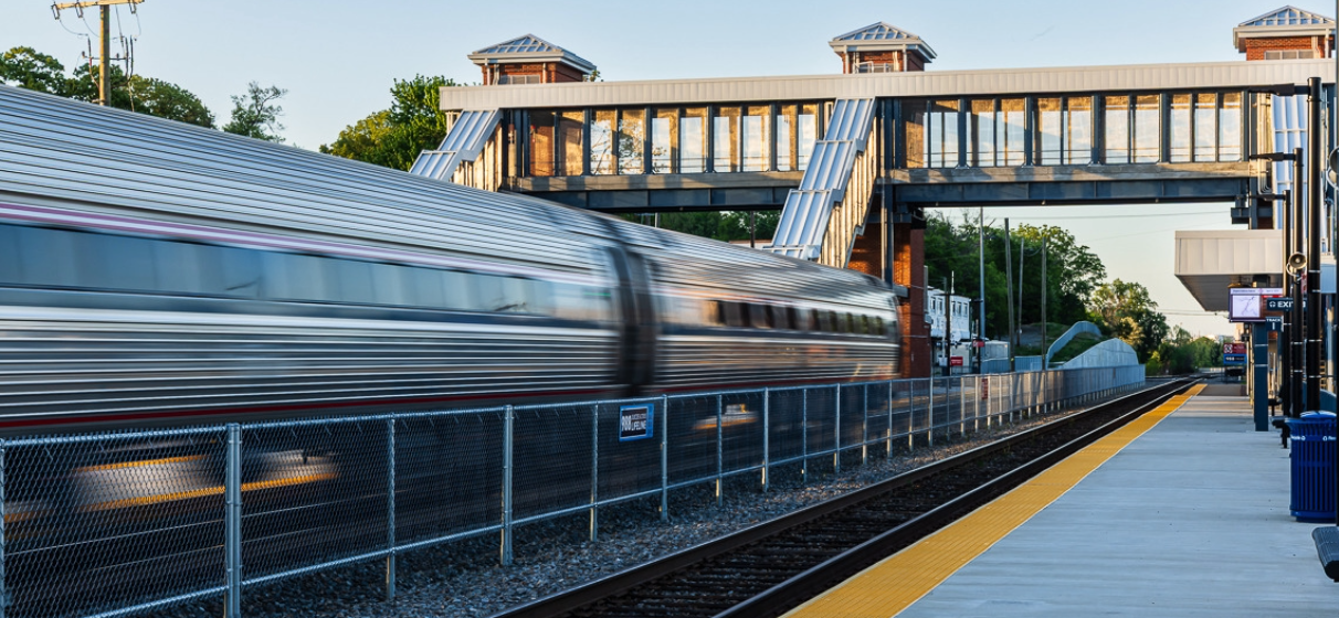 Blurred Amtrak train passing through a station in Virginia.