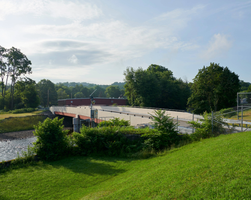 Ground view of green embankment with bridge crossing for Parker Street Bridge in Scranton, PA.