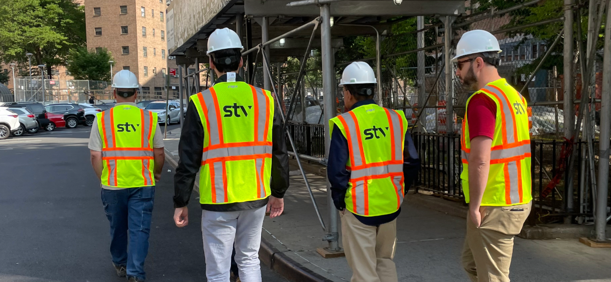 STV PM/CM team members, wearing branded STV construction vests, at a NYCHA construction site.