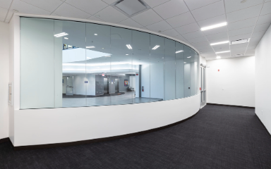 White hallway with grey carpet and reflective glass