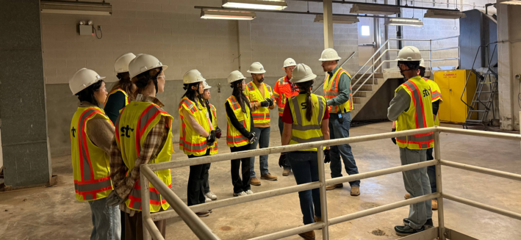 Group photo of Austin team with UT students at a project site