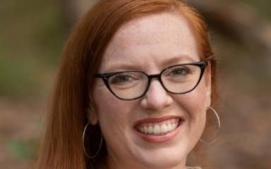 Headshot of woman with glasses with shoulder-length hair