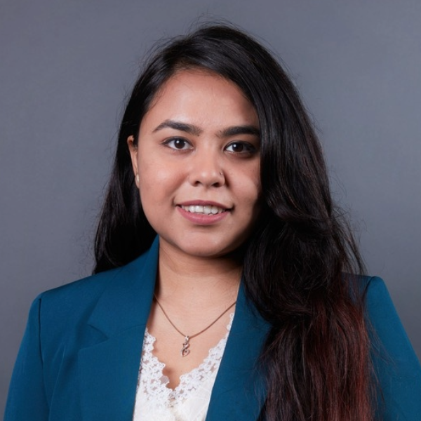 Headshot of woman in dark hair with blue blazer.