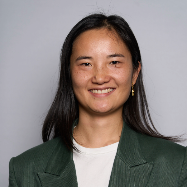 Headshot of woman in gray blazer white top and long brownhair