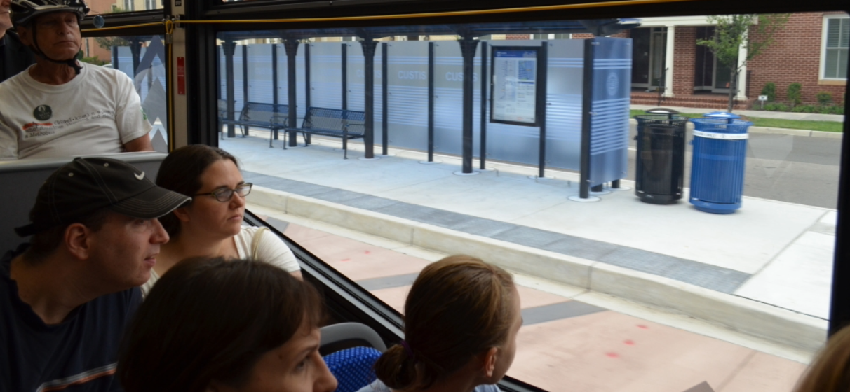 Interior of bus in motion while seated passengers look out window