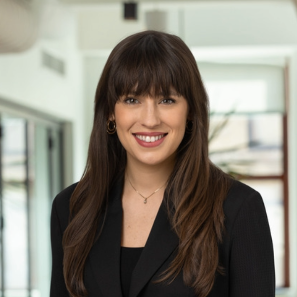Headshot of woman in black blazer with long brown hair