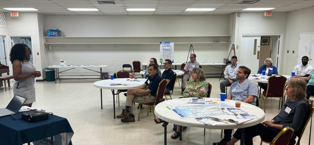 Woman leading presentation to groups at round tables