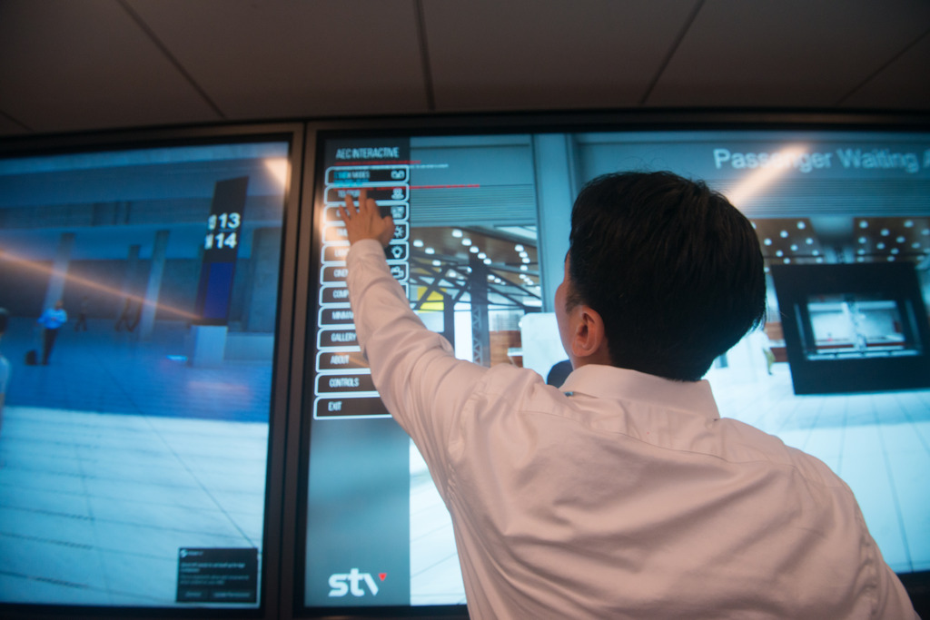 Man at large interactive screen pointing
