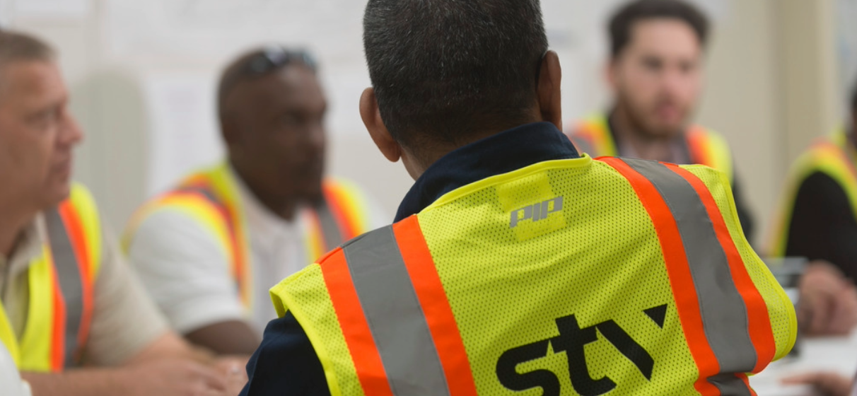 View of back of person wearing STV-branded safety vest