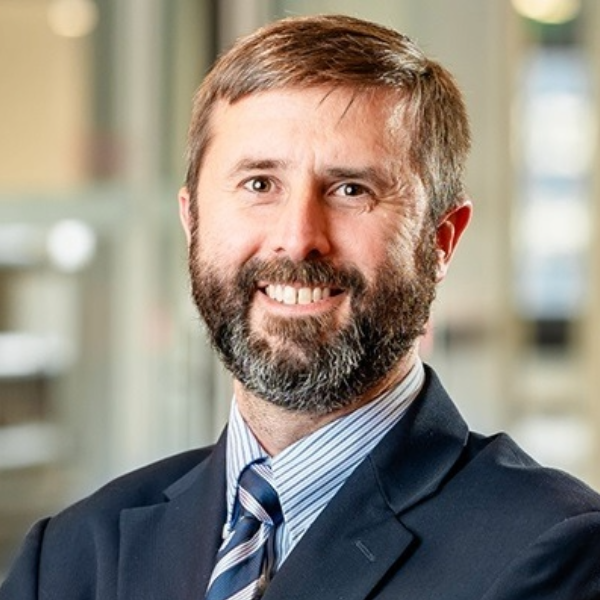 Headshot of man with beard in dark suit and jacket