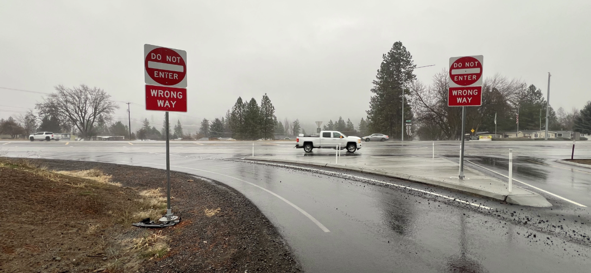 Rainy highway ramp with wrong way driving signs