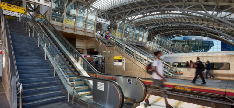 view of elevator from interior subway station with passengers walking