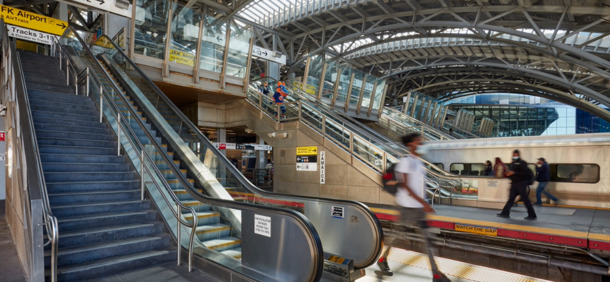 view of elevator from interior subway station with passengers walking