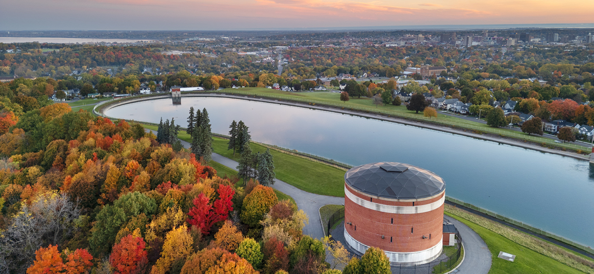 Aerial view of Syracuse, New York, showcasing a water treatment facility, fall foliage and surrounding homes.