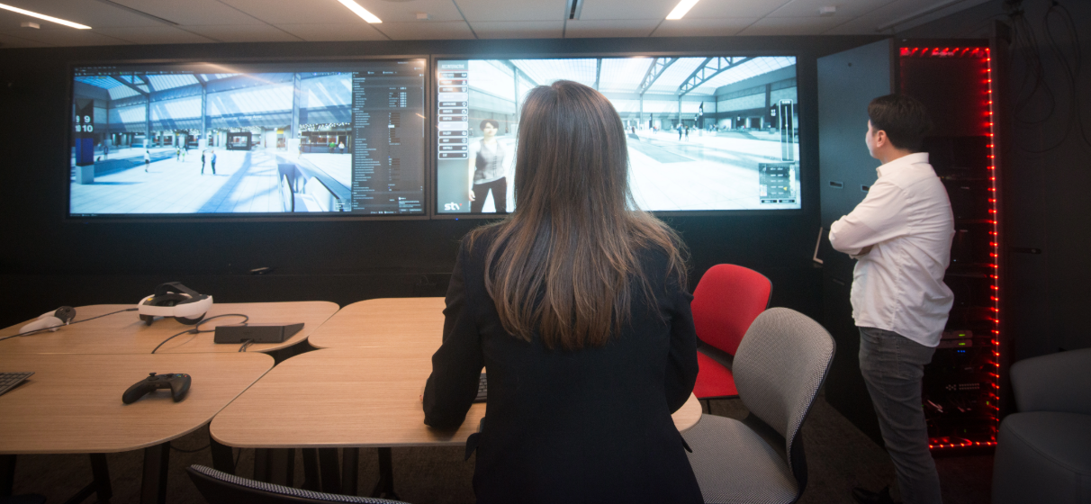 STV employees view animated rendering on video screens in office.