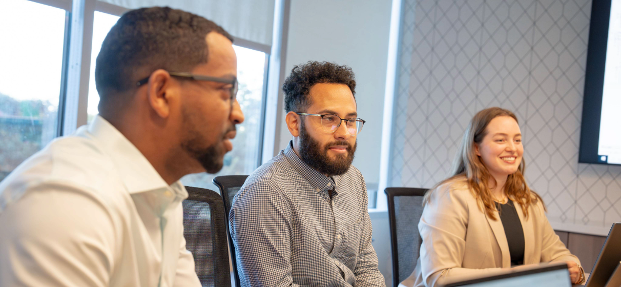 Three STV employees sit in a conference room in our Dallas office.