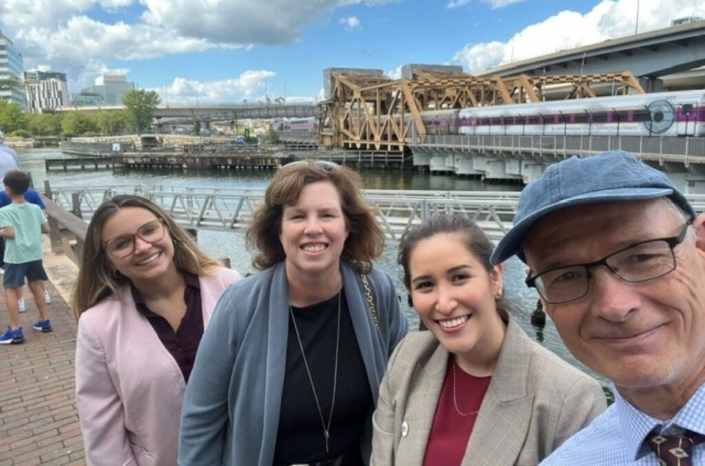 STV team members attending the North Station Draw One Bridge grondbreaking ceremony with the existing bridge in the background.