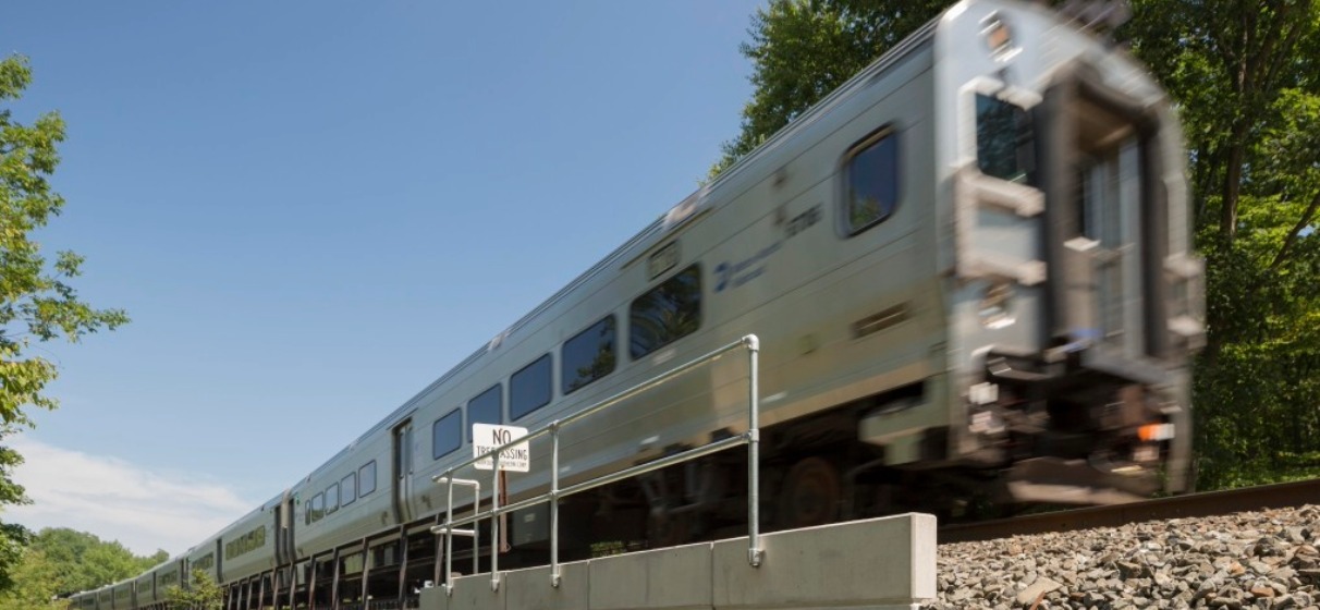 View of MNR train overhead on outdoor track moving forward